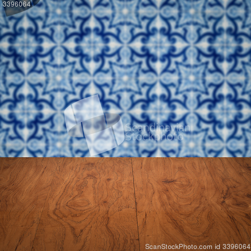 Image of Wood table top and blur vintage ceramic tile pattern wall