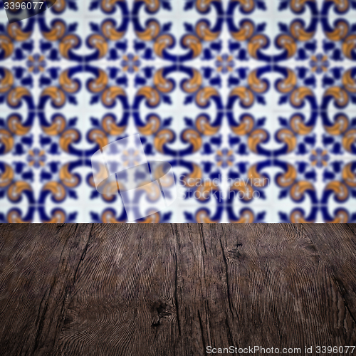 Image of Wood table top and blur vintage ceramic tile pattern wall