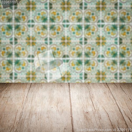 Image of Wood table top and blur vintage ceramic tile pattern wall