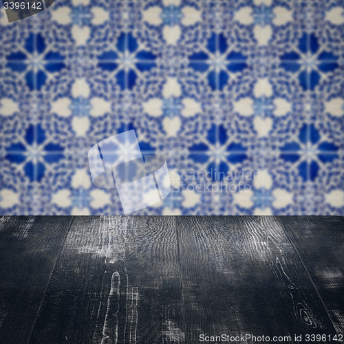 Image of Wood table top and blur vintage ceramic tile pattern wall