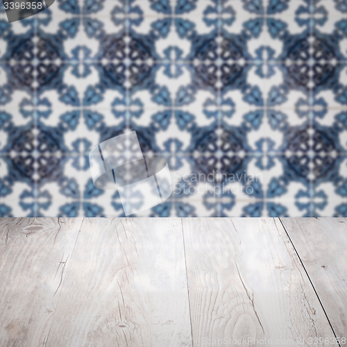 Image of Wood table top and blur vintage ceramic tile pattern wall