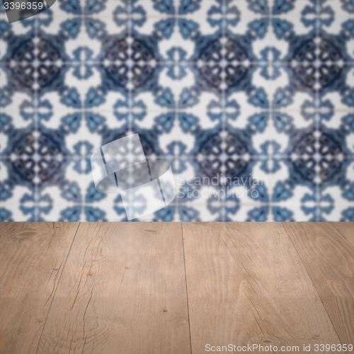 Image of Wood table top and blur vintage ceramic tile pattern wall