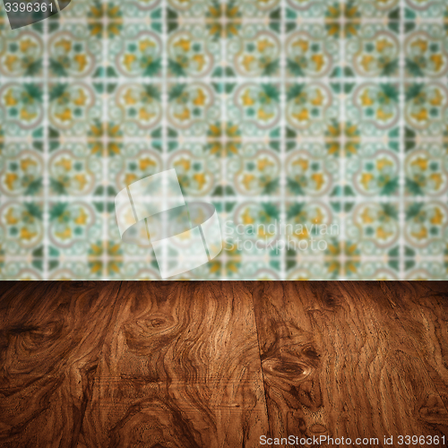 Image of Wood table top and blur vintage ceramic tile pattern wall