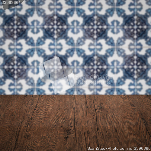 Image of Wood table top and blur vintage ceramic tile pattern wall