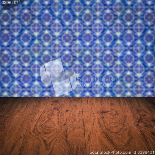 Image of Wood table top and blur vintage ceramic tile pattern wall