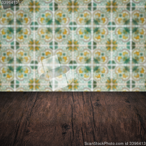 Image of Wood table top and blur vintage ceramic tile pattern wall