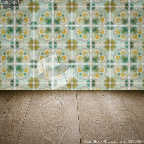 Image of Wood table top and blur vintage ceramic tile pattern wall