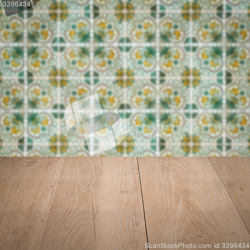 Image of Wood table top and blur vintage ceramic tile pattern wall