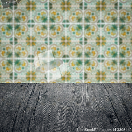 Image of Wood table top and blur vintage ceramic tile pattern wall