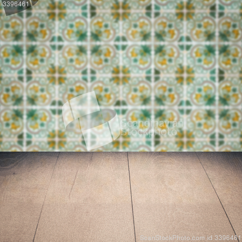 Image of Wood table top and blur vintage ceramic tile pattern wall