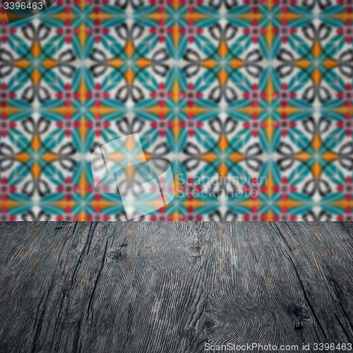Image of Wood table top and blur vintage ceramic tile pattern wall