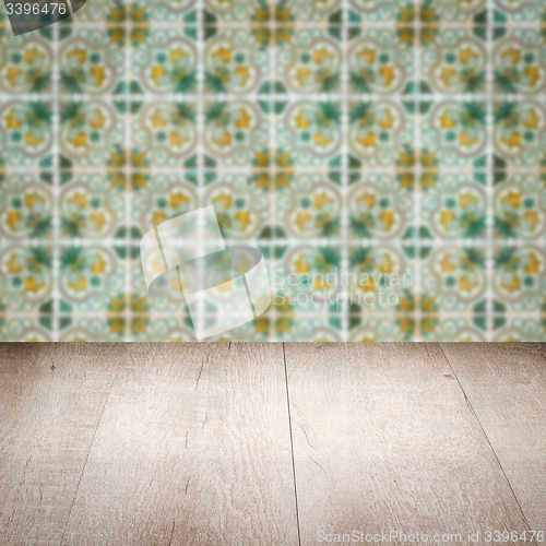 Image of Wood table top and blur vintage ceramic tile pattern wall