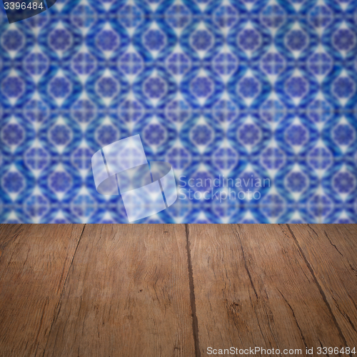 Image of Wood table top and blur vintage ceramic tile pattern wall