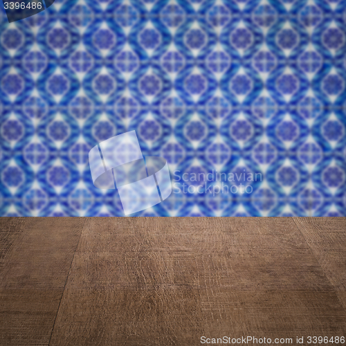 Image of Wood table top and blur vintage ceramic tile pattern wall