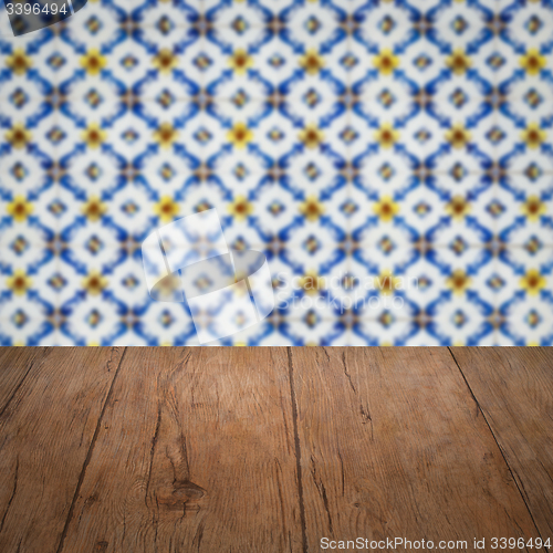 Image of Wood table top and blur vintage ceramic tile pattern wall