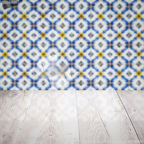 Image of Wood table top and blur vintage ceramic tile pattern wall