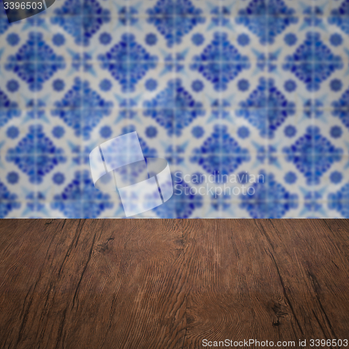 Image of Wood table top and blur vintage ceramic tile pattern wall
