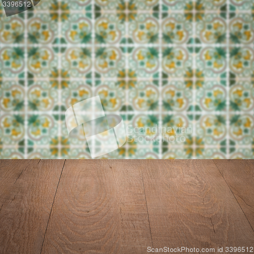 Image of Wood table top and blur vintage ceramic tile pattern wall