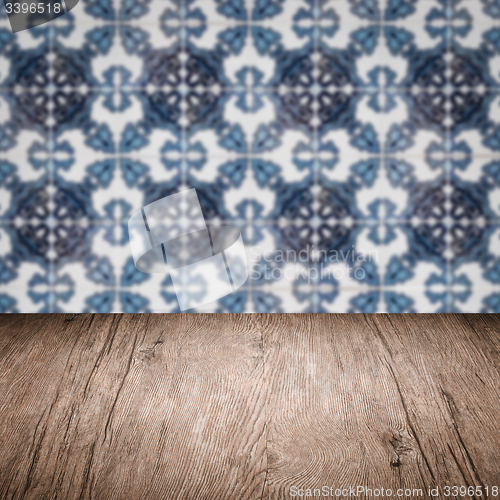 Image of Wood table top and blur vintage ceramic tile pattern wall