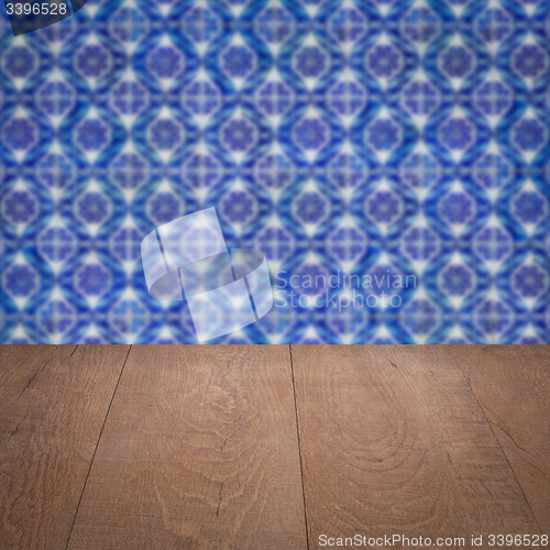 Image of Wood table top and blur vintage ceramic tile pattern wall