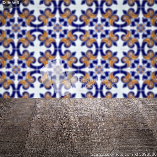 Image of Wood table top and blur vintage ceramic tile pattern wall