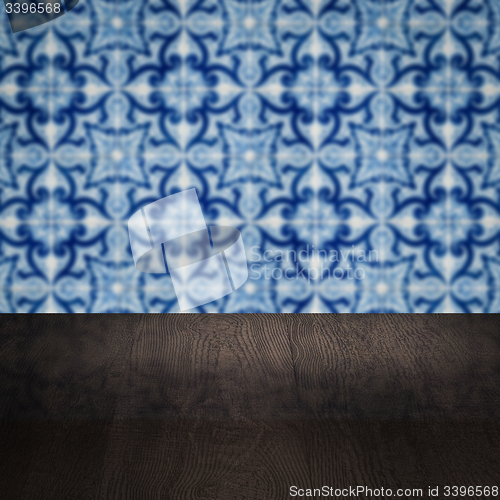 Image of Wood table top and blur vintage ceramic tile pattern wall