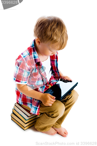 Image of boy with a Tablet PC sitting on the books