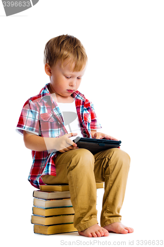 Image of boy with a Tablet PC sitting on the books