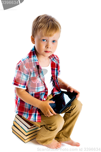 Image of boy with a Tablet PC sitting on the books