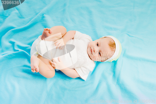 Image of baby lying on a blue plaid