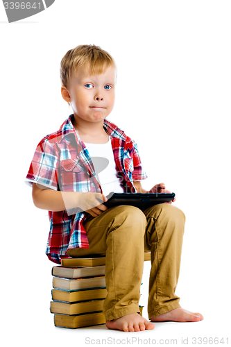 Image of boy with a Tablet PC sitting on the books