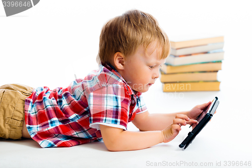 Image of small boy with tablet computer lying on the floor