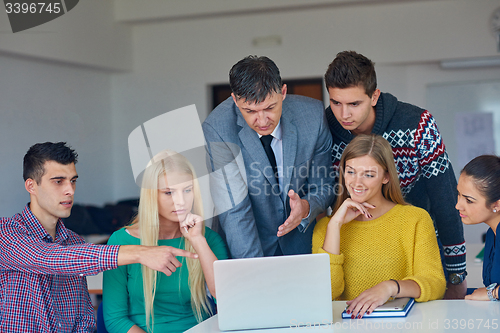 Image of group of students getting suppport from teacher