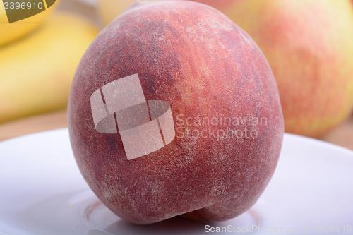 Image of peach,  apple and strawberry on wooden plate 