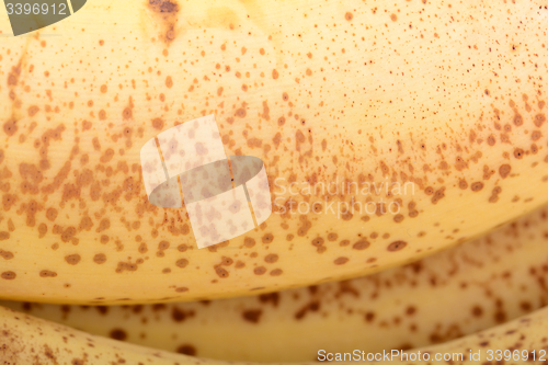 Image of Extreme  close-up of ripe banana peel. Texture showing brown spots on yellow background.