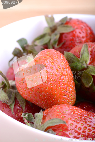 Image of Closeup of large fresh strawberries in white bowl