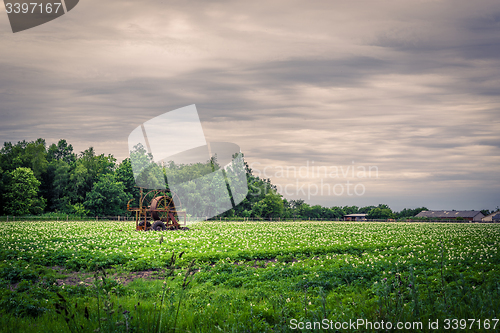 Image of Water pump on a green field in dark weather