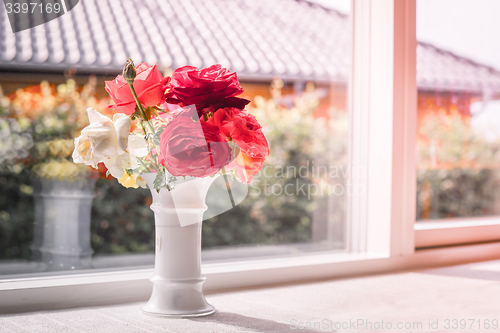 Image of Bouquet of roses in a window