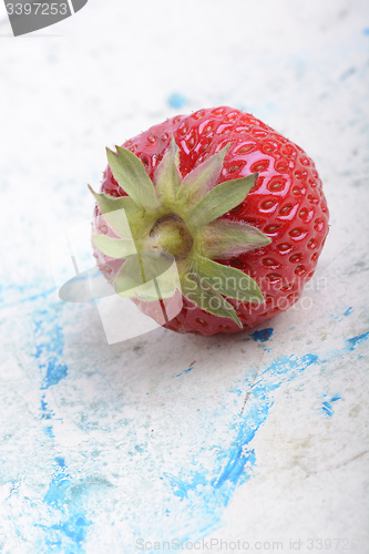 Image of big fresh strawberry with green leave, close up