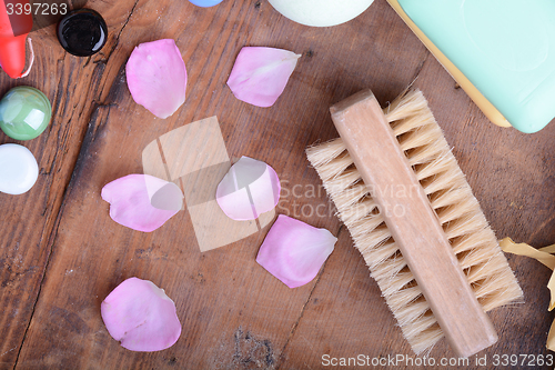 Image of comb, sea salt, spa stones and flower petals on wooden table, closeup