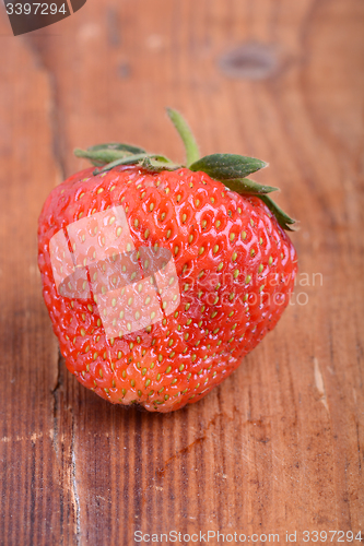 Image of Strawberry on wooden plate close up