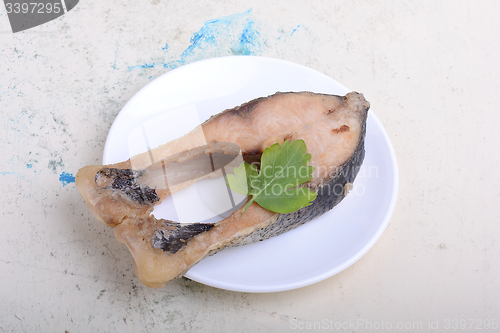 Image of Frying pan with one roasted salmon steaks, view from above