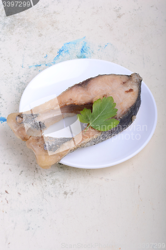 Image of Frying pan with one roasted salmon steaks, view from above