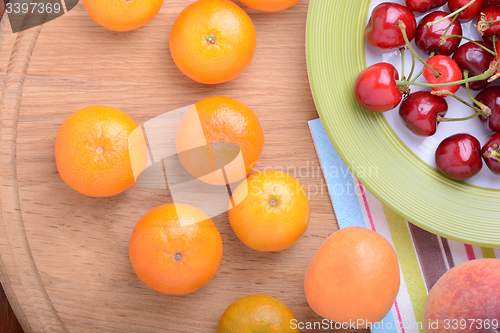 Image of mandarin, peach and cherry fresh fruits and berries, summer health food