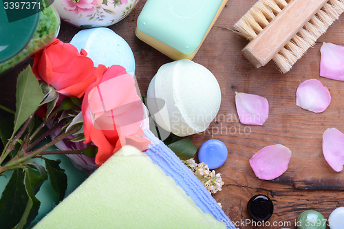 Image of comb, sea salt, spa stones and flower petals on wooden table, closeup