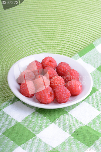 Image of Fresh raspberries. Closeup of fruits on a white plate