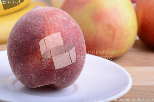 Image of peach,  apple and strawberry on wooden plate 