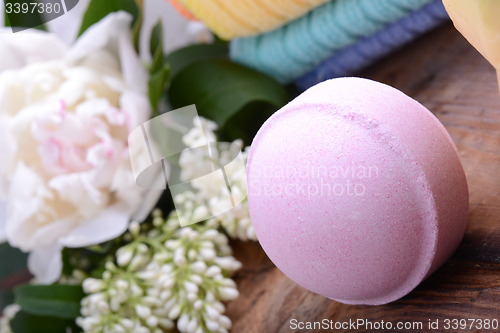 Image of towels, aroma spa, flower and sea salt on wooden plate 