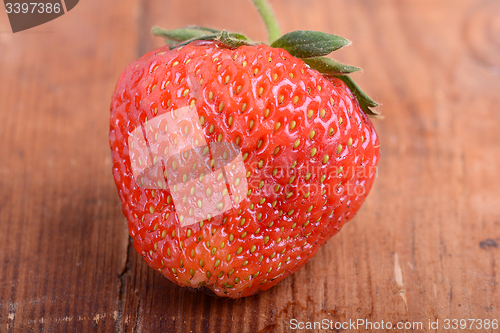 Image of Strawberry on wooden plate close up