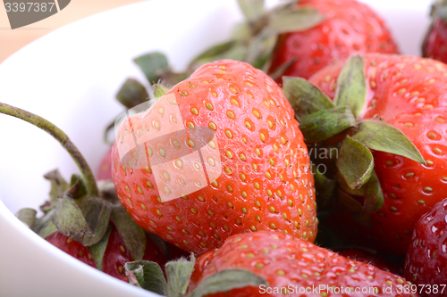 Image of Closeup of large fresh strawberries in white bowl